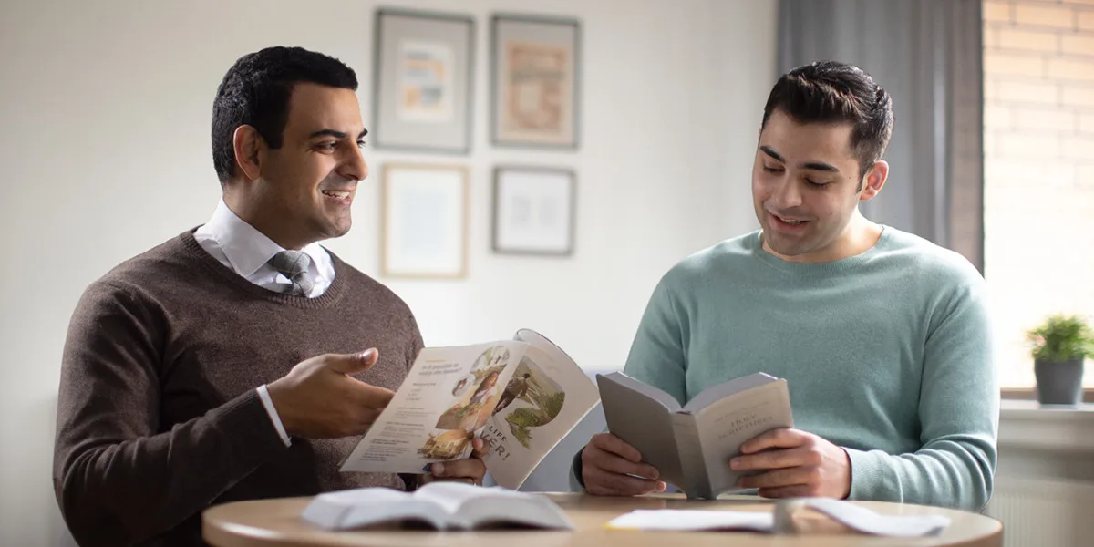 Two men talking over an open Bible